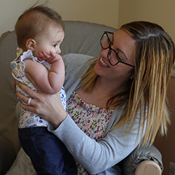 Teacher holding and interacting with an infant during nurturing daycare classroom time.