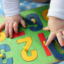 baby hands working on number puzzle