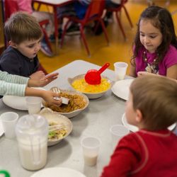 niños almorzando alrededor de la mesa