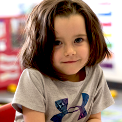 niña sonriendo en el escritorio