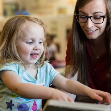 teacher helping little girl